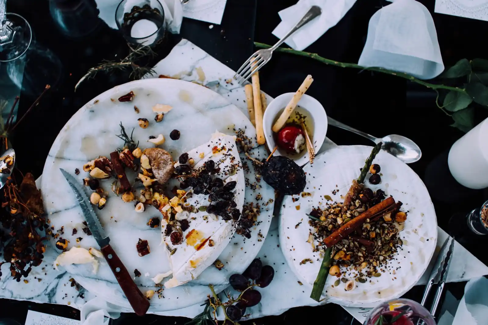 An overhead view of plates holding the remains of finished dishes after a shared meal.