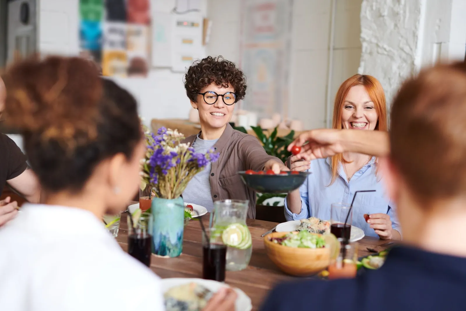 A group of friends and family sharing a meal together at an indoor table.