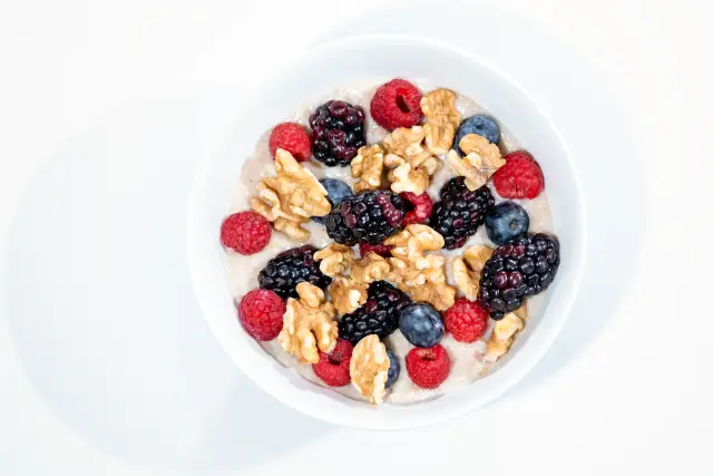 A vibrant bowl of mixed berries, walnuts, and oats.
