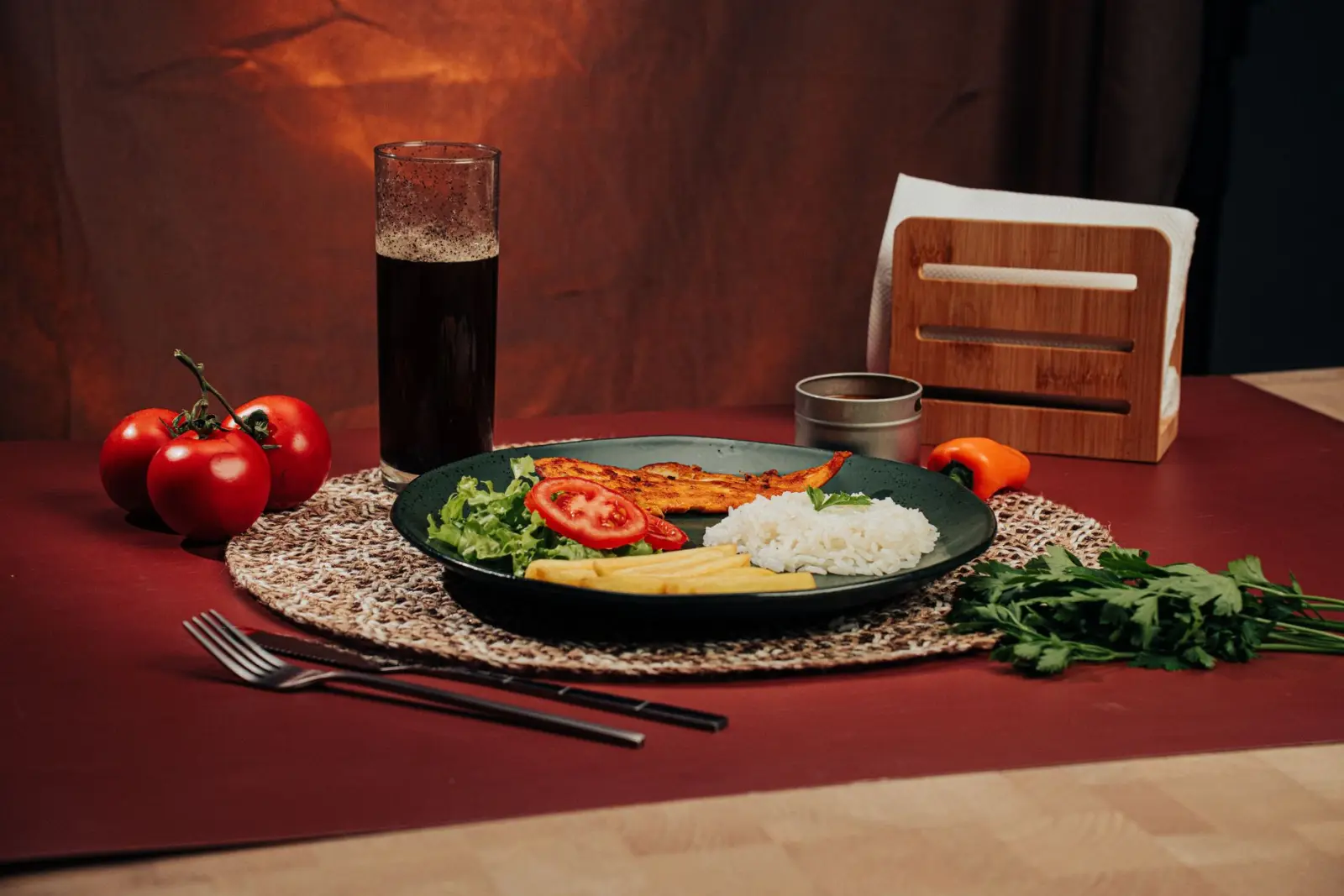 A plate of rice, grilled chicken and vegetables arranged on a table.