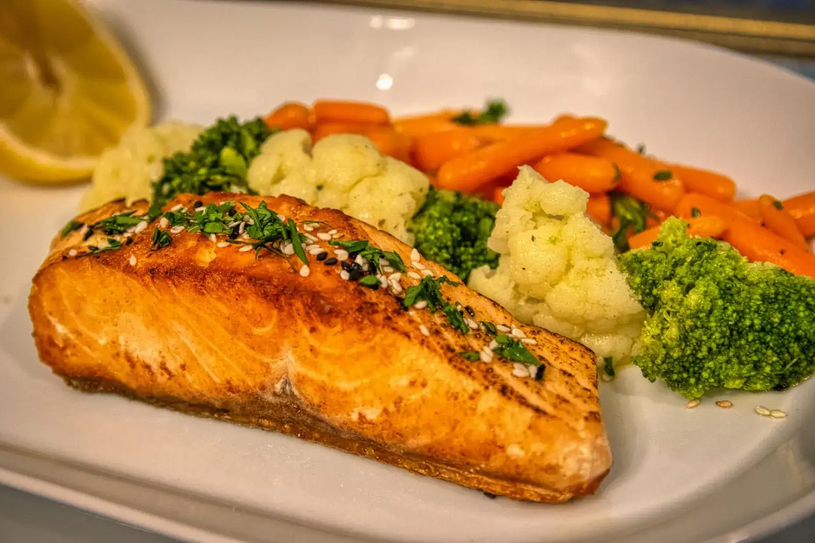 Grilled salmon served with mixed vegetables on a plate.
