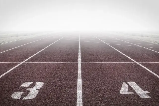 Empty numbered lanes of a running track stretching into the distance.