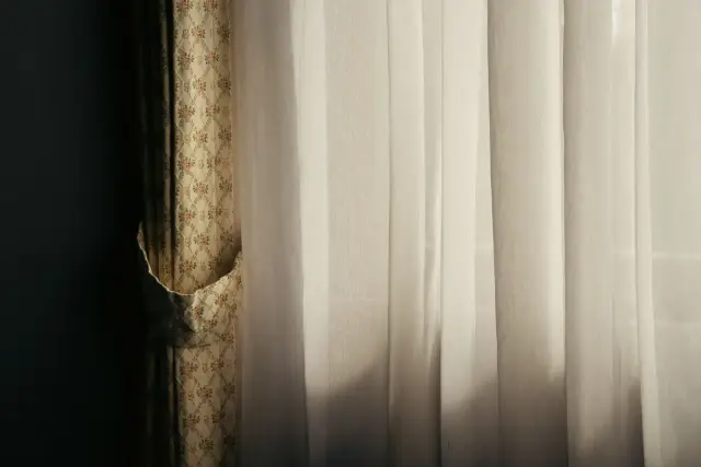 A woman gazing thoughtfully out of a window.