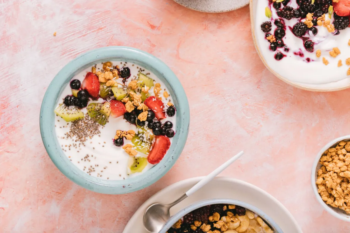 Bowls of Greek yogurt topped with berries and granola, an easy high-protein option for hitting a protein floor.