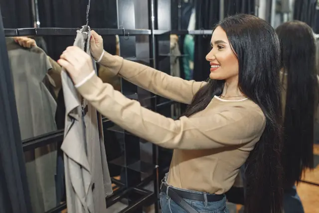 A woman smiling while lacing up shoes at home.