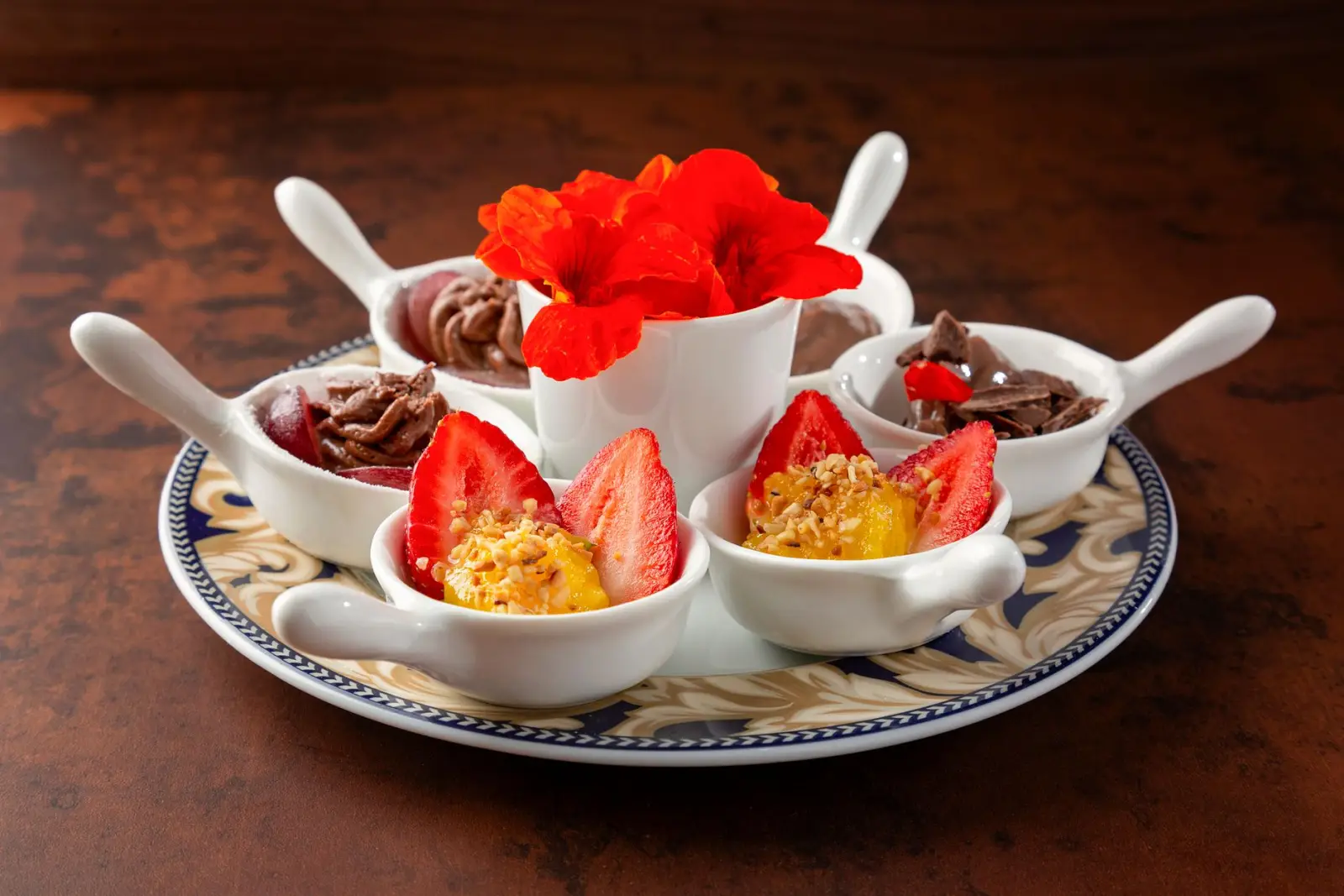 A dessert plate with strawberries and chocolate, plated after a meal.